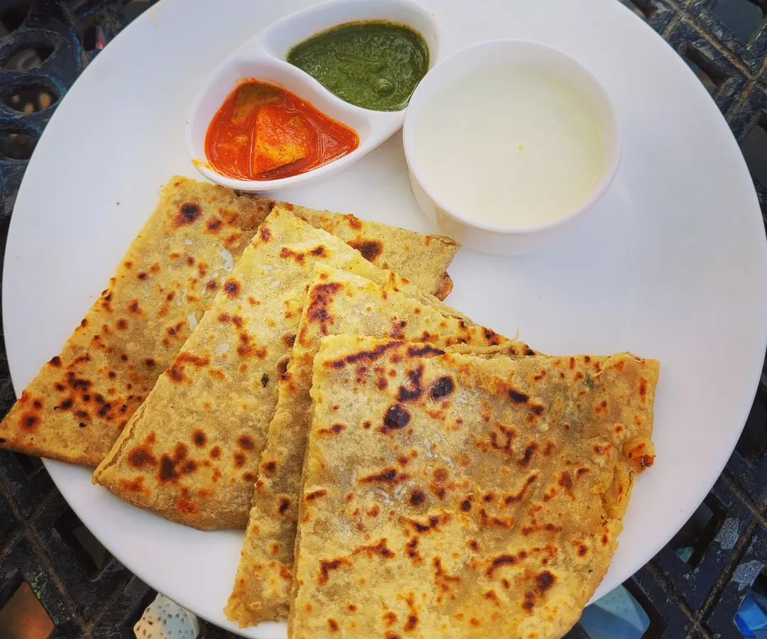 Nothing beats a plate of hot, homemade parathas. Here I have a variety of stuffed flatbreads including Aloo, Gobi, and Paneer paratha, served with fresh dahi, spicy mango achar, and green chutney.