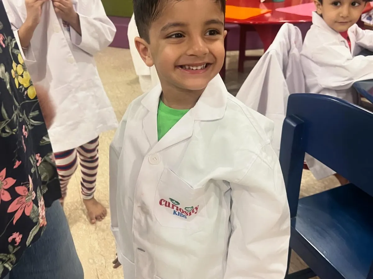 Look at that proud smile! Our little scientists love dressing up in lab coats for our hands-on STEM workshops, where they feel like real inventors.