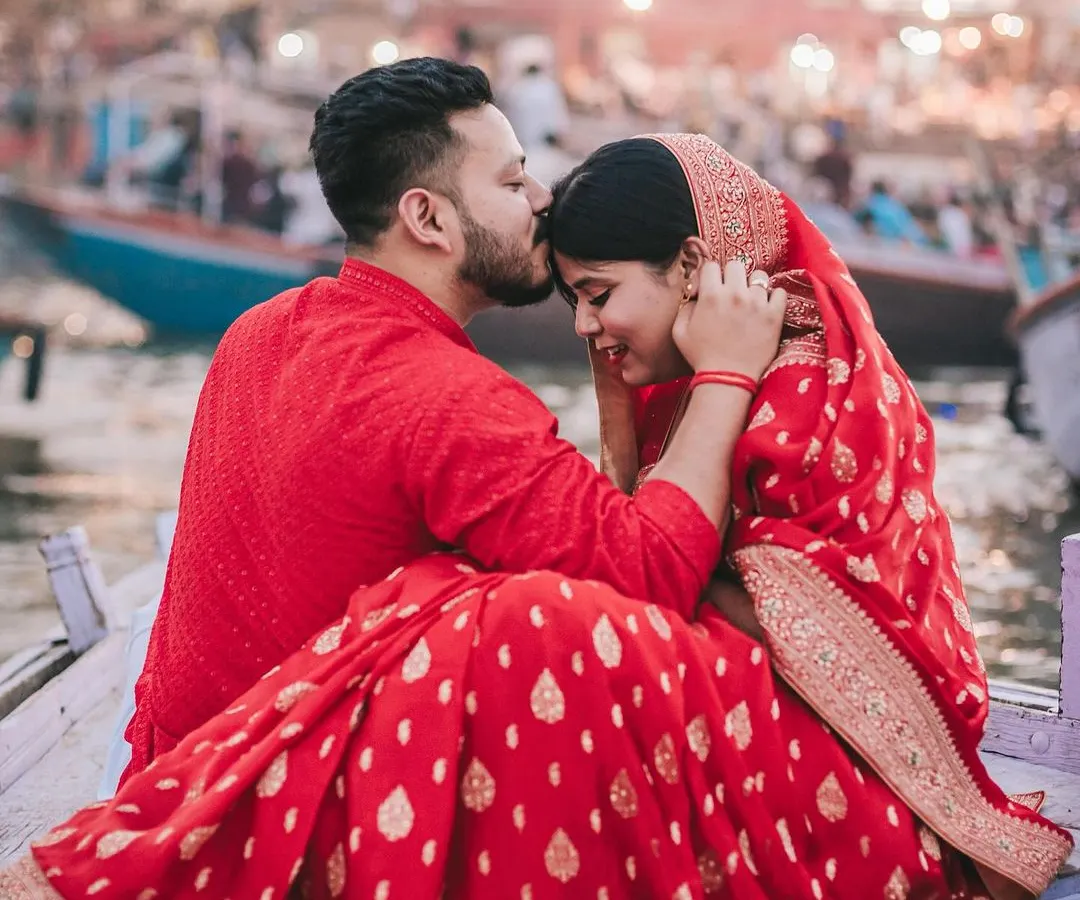 This pre-wedding shoot on the ghats of Varanasi was about finding a quiet moment of connection amidst the city's eternal rhythm. The groom's gentle kiss and the bride's serene smile tell a story of love against a backdrop of timeless tradition.