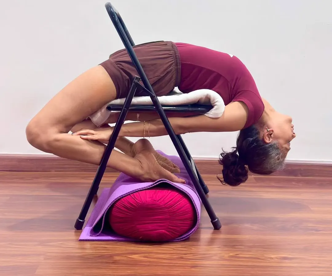 I demonstrate a deep backbend, Kapotasana, using a chair for support. Props are not shortcuts; they are tools for intelligence. They allow every student, regardless of stiffness, to safely explore the full depth of an asana, opening the thoracic spine and cultivating a state of courage and receptivity.
