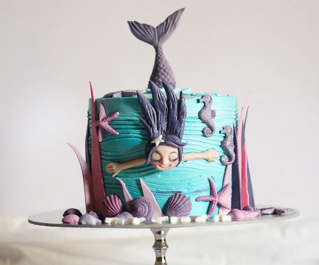 I had so much fun creating my version of the popular swimming mermaid cake. This under the sea theme cake features a hand-sculpted mermaid, complete with shimmering scales and surrounded by little seahorses, starfish, and shells. It's perfect for a magical birthday party.