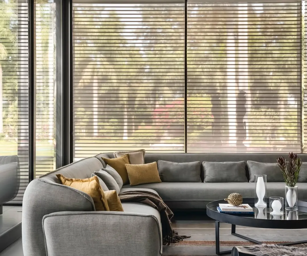 Inside the pool house, comfort is key. I selected this large, curved sectional sofa to create an intimate lounge area that still feels open to the surrounding views. The neutral grey fabric is complemented by warm mustard pillows, adding a pop of color that echoes the natural light.