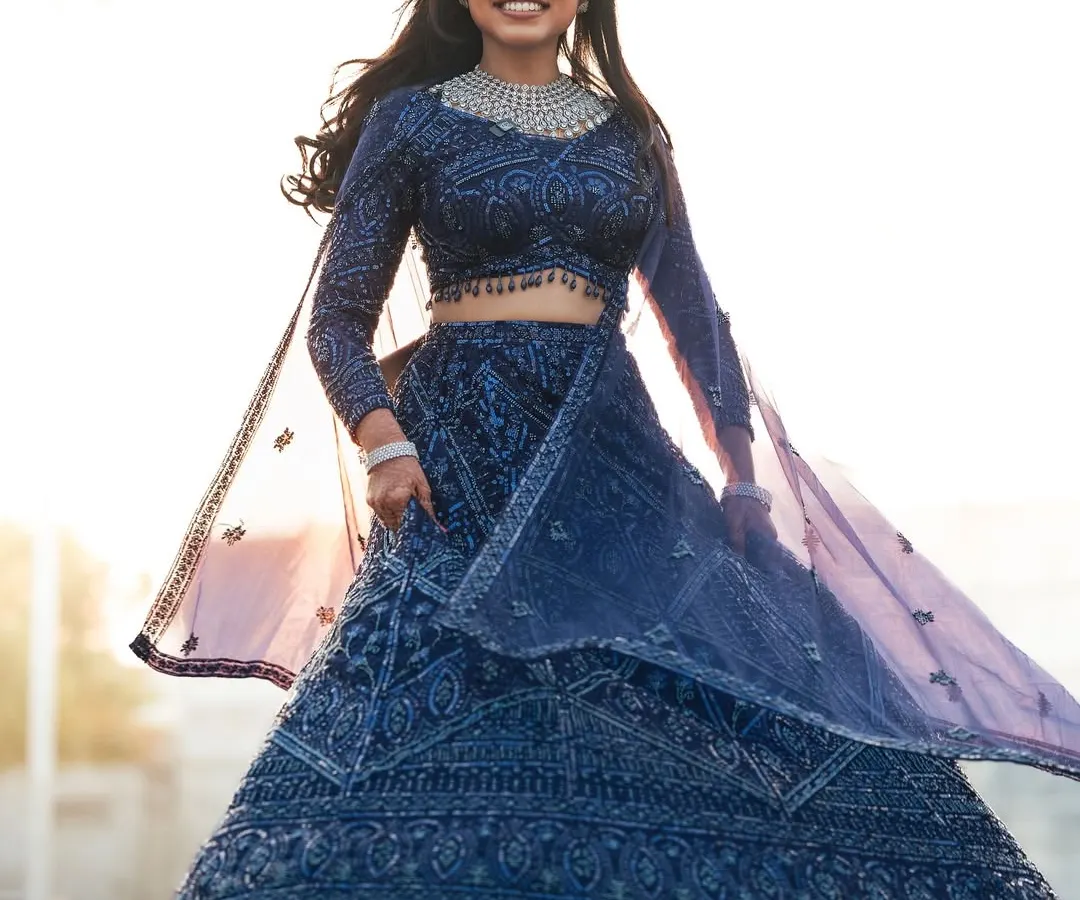 Capturing the pure joy of a reception look. My beautiful bride, Dr. Akshara, is absolutely radiant in this twirling shot, showcasing her sparkling navy blue lehenga. The glam makeup and flowing hair were designed to be perfect for a night of celebration.