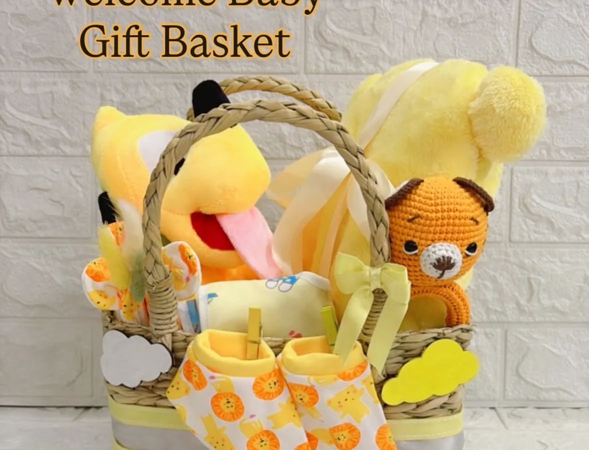 I call this my "Bundle of Sunshine" basket, designed to bring a warm welcome to any newborn. This gender-neutral gift set includes a cheerful Pluto soft toy, a hand-knitted tiger, and a matching set of soft cotton booties and essentials.