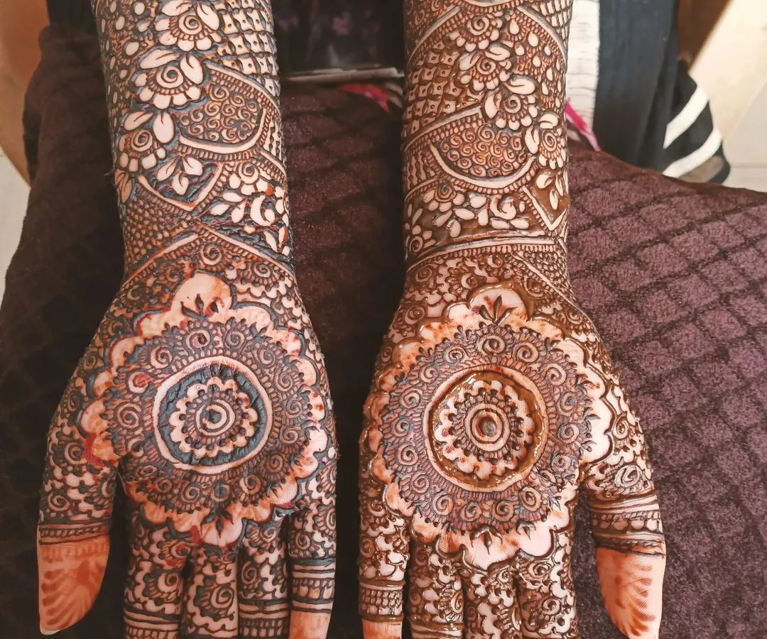 I love creating symmetrical designs like this one, where a central mandala on the palm is the star. The pattern extends up the arm with a mix of paisleys and florals, making it a bold choice for any party.