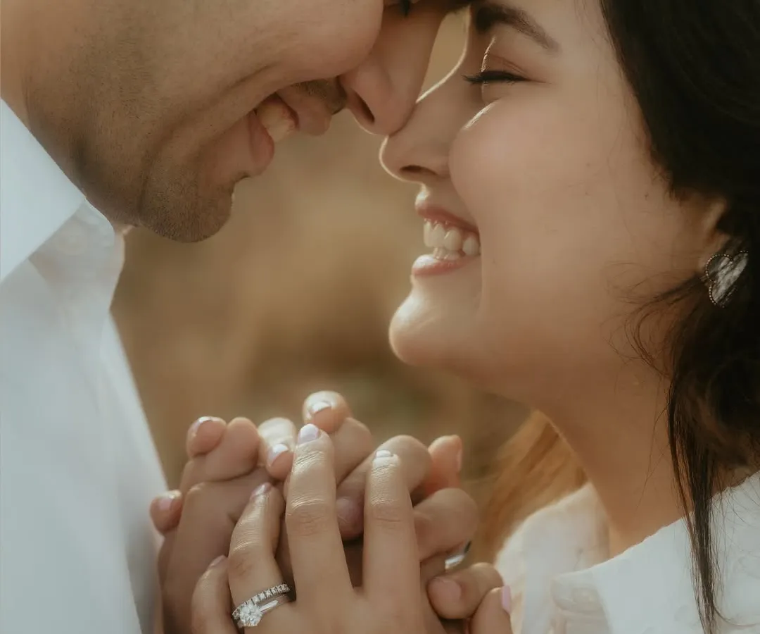 An intimate close-up of a couple, their faces close together, sharing a genuine, joyful smile. This shot focuses on the raw emotion and connection, capturing the essence of a candid couple portrait.