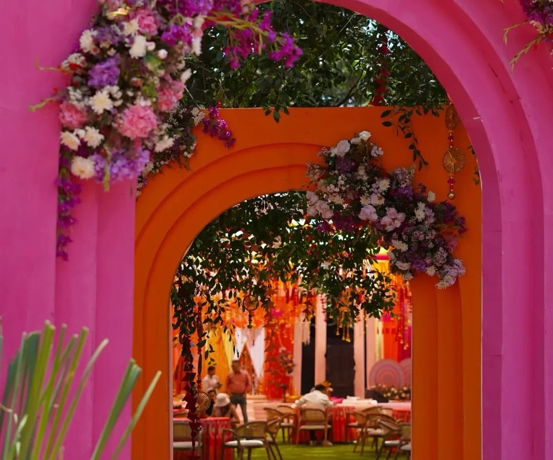 Haldi celebrations should be an explosion of joy and color. We crafted these vibrant pink and orange arches, adorned with lush floral arrangements, to create a picture perfect, fun-filled entrance that feels both festive and deeply personal.