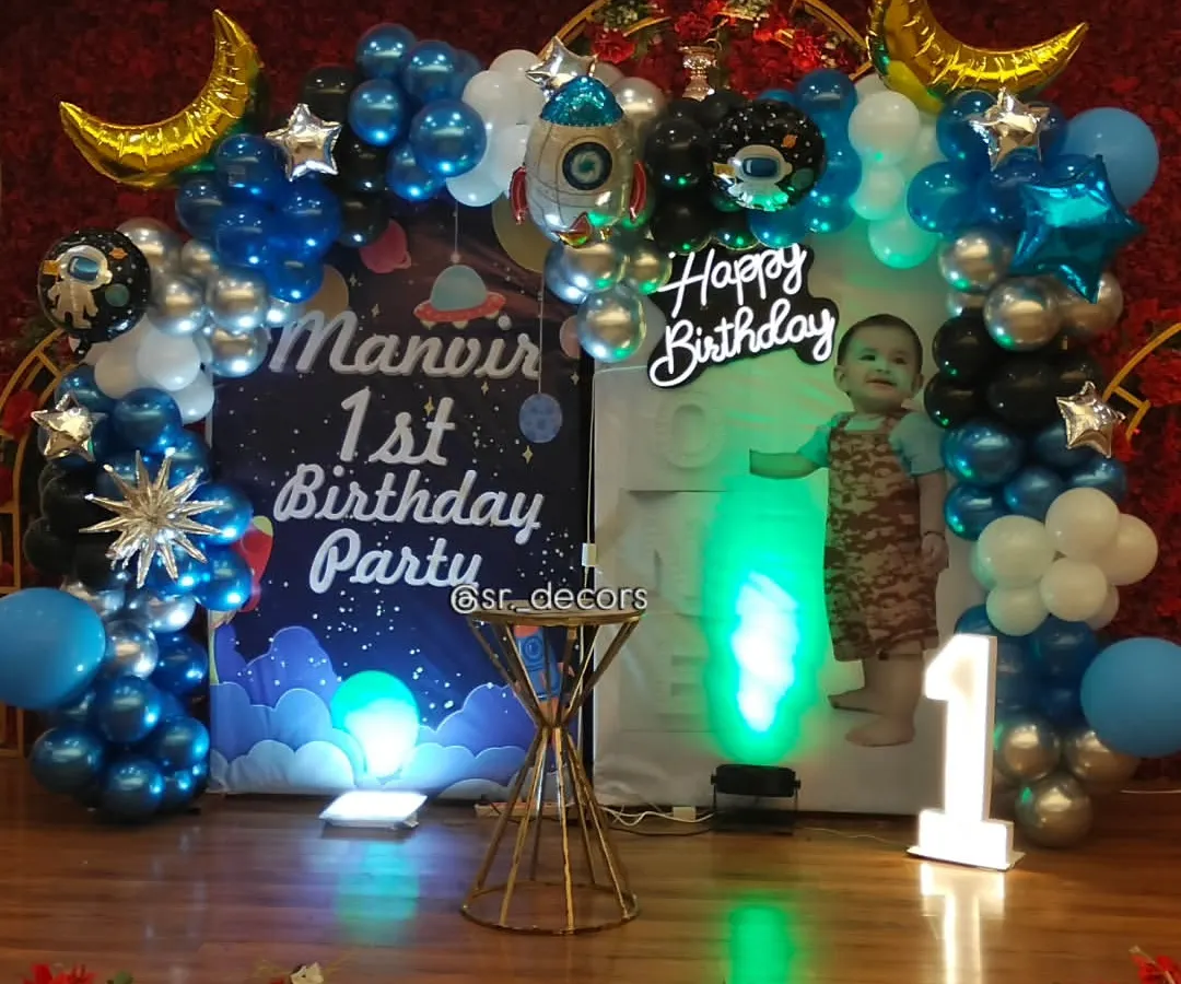 We bring themes to life with custom setups like this space adventure for a first birthday, featuring a personalized backdrop, rocket and planet foil balloons, and a light-up number '1' to mark the special milestone.