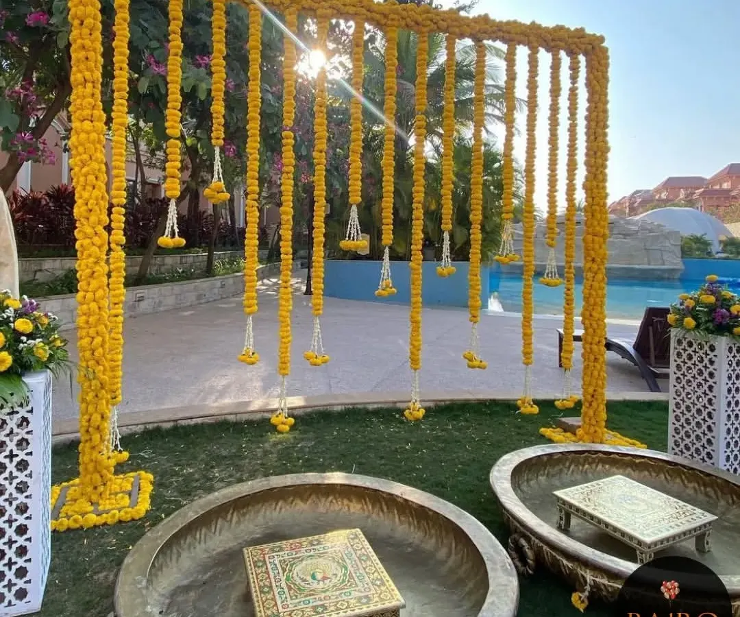 For this outdoor Haldi ceremony, I designed a beautiful backdrop using curtains of fresh marigold flowers. The setup includes traditional brass urlis and ornate chowkis, creating a perfect blend of elegance and festive tradition for the bride's haldi.