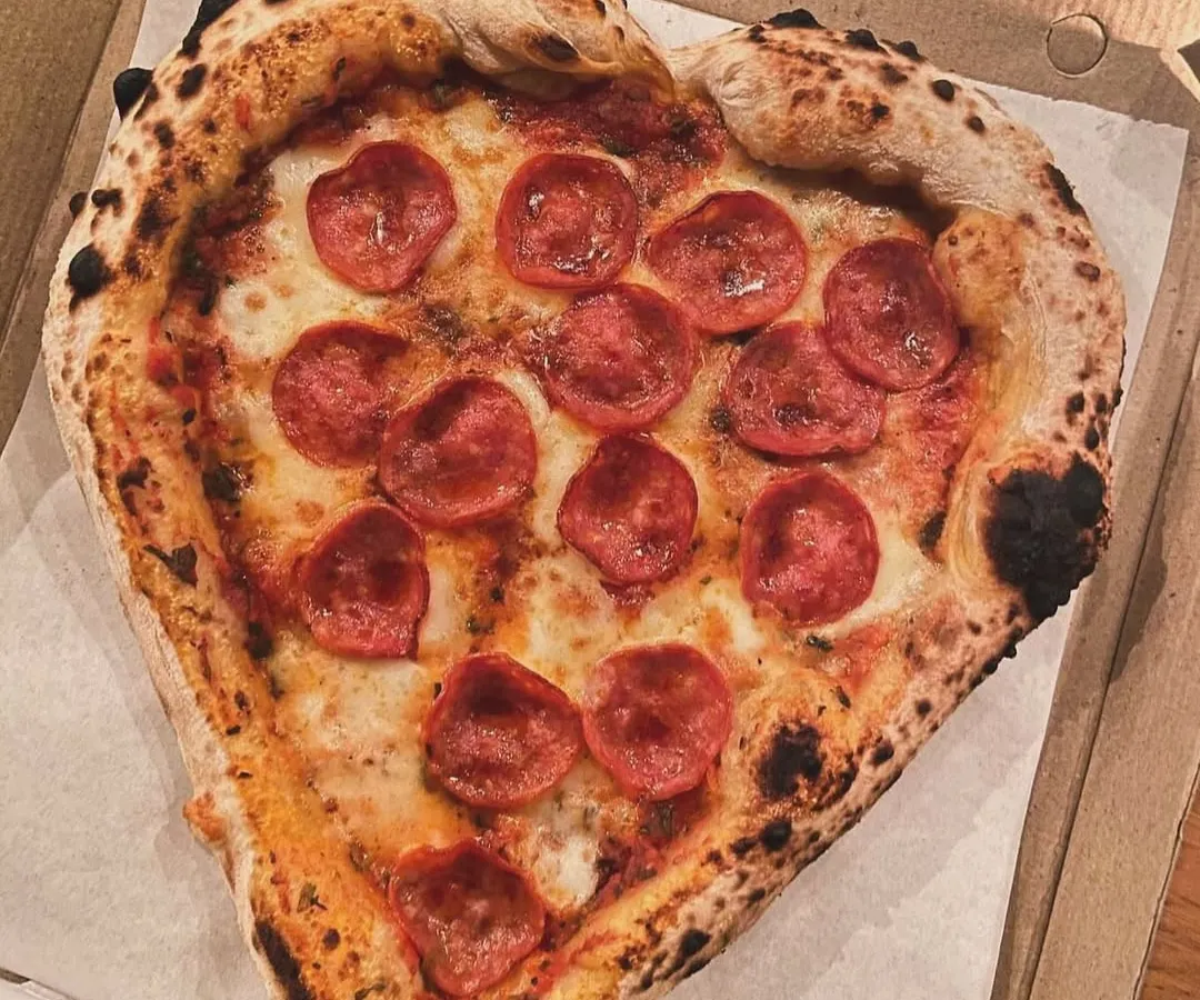 Nothing says "Amore" like a heart-shaped pizza. I love making these for special occasions. This one is a classic pepperoni, fresh from the wood-fired oven with a perfectly leopard-spotted Neapolitan crust.