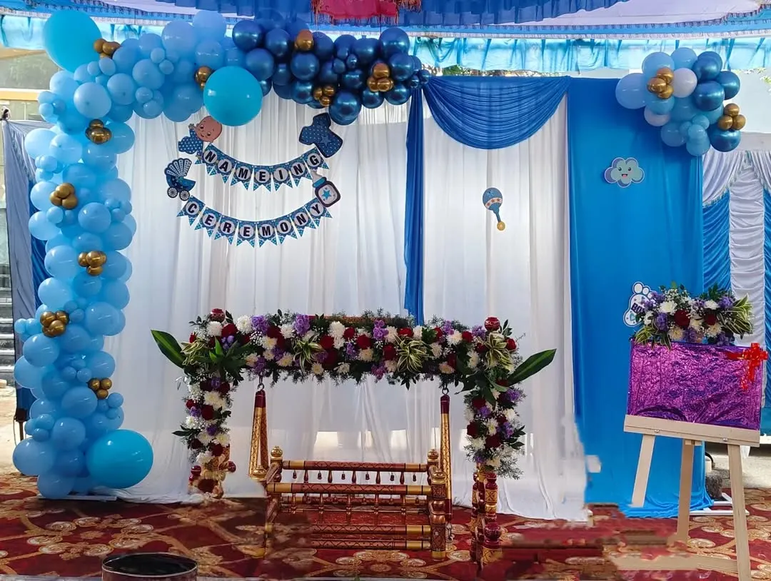 Here is a beautiful setup for a traditional Namakarana or naming ceremony. We decorated the wooden cradle, or thottilu, with fresh flowers and created a backdrop with blue balloons and soft white drapes to welcome the little one.