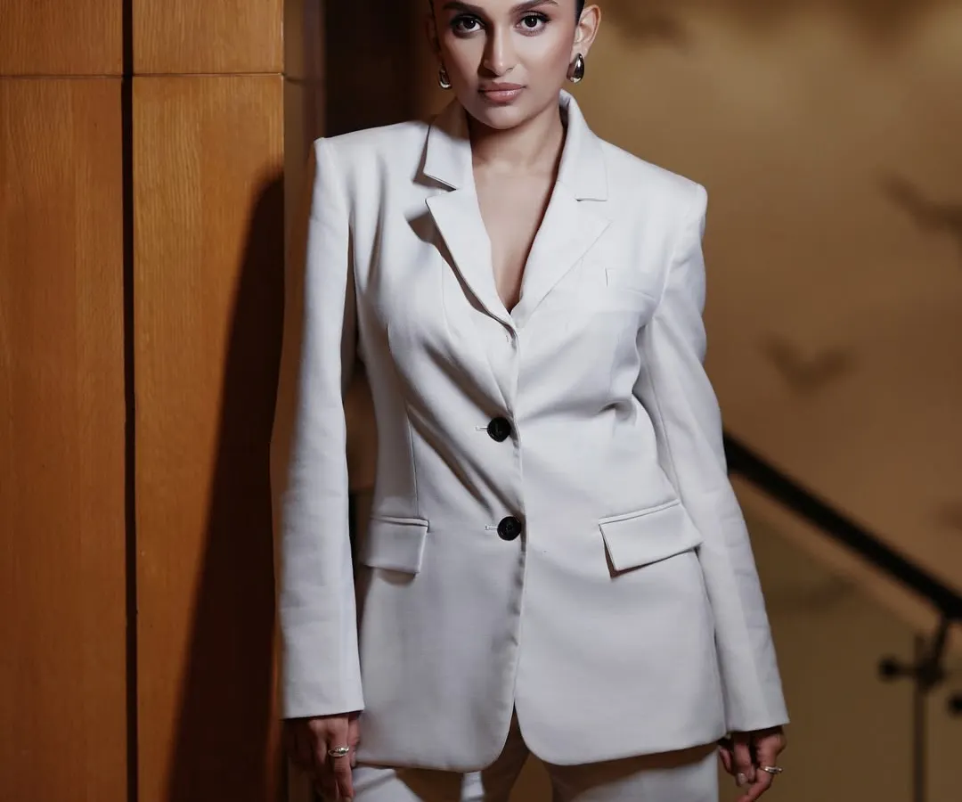 Power dressing is an attitude. For this studio portrait, we went for a clean, sharp look with a white power suit. The focus is on the confident posture and direct gaze, creating a 'boss mode' vibe that’s both elegant and strong.
