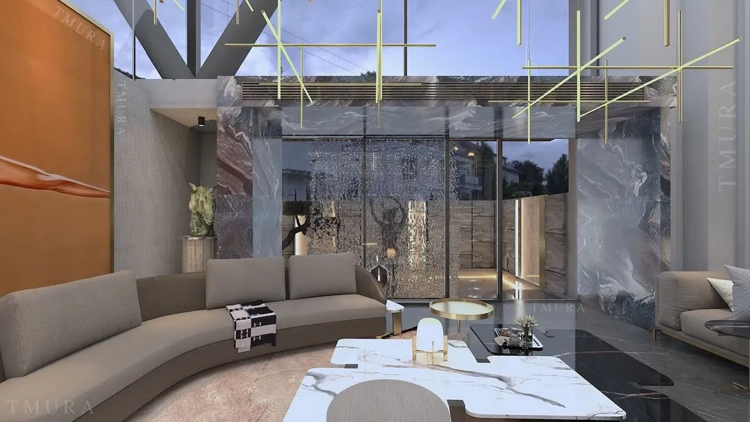 This double-height living room embodies opulence. We used bookmatched marble slabs to create a dramatic feature wall, while our custom-designed brass lighting grid descends from the ceiling, illuminating the space and our in-house manufactured curved sofa.
