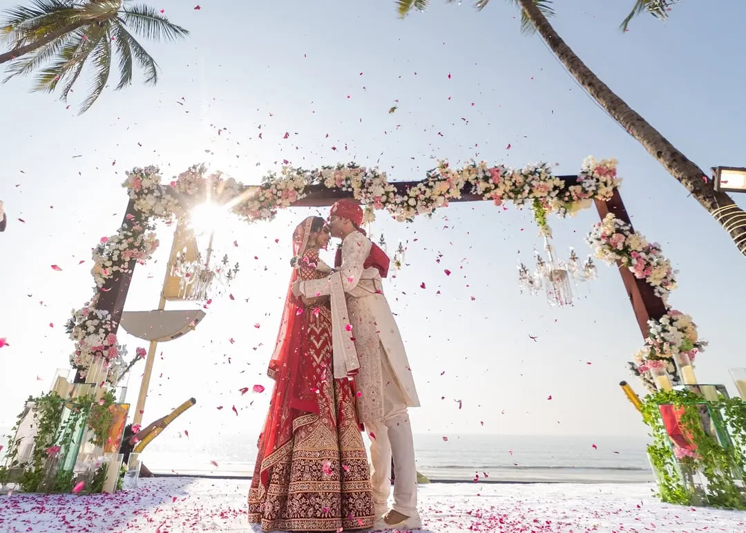 A perfect moment under the Goa sun. As the flower petals rained down, Pooja and Aayush sealed their vows with a kiss, with the sound of the ocean behind them. We believe some moments are pure magic, and this was one of them.