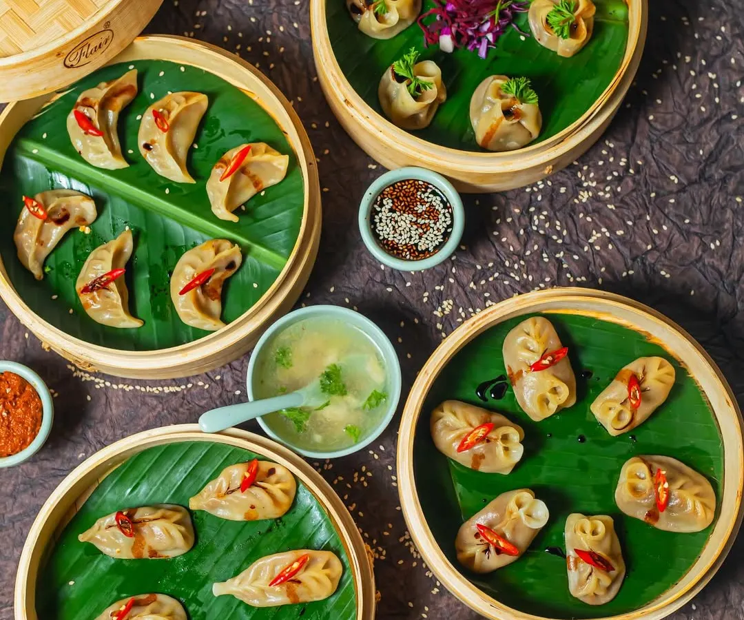 A feast of our handcrafted momos, steamed to perfection in traditional bamboo baskets. This spread shows the variety we offer, each dumpling filled with spiced ingredients and served with our signature clear soup and dipping sauces. This is the heart of Himalayan comfort food.