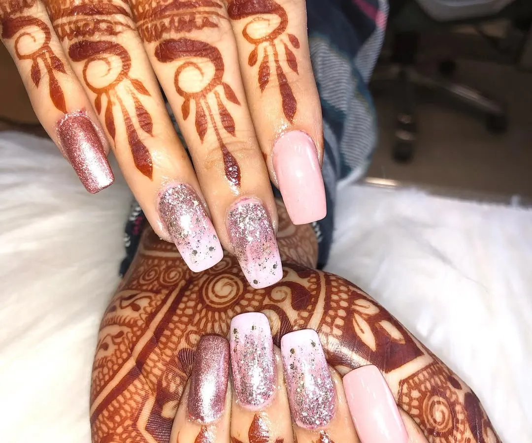 A perfect example of a complete bridal look. Here, I've paired intricate, traditional mehendi covering the full hand with elegant rose gold and glitter nail extensions for a glamorous finish.
