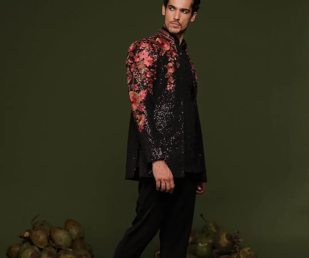 This is where tradition meets high fashion. A black, sequined Indo-Western Jodhpuri jacket with vibrant floral embroidery on the shoulders, designed for the man who wants to make a bold statement at a reception or sangeet.