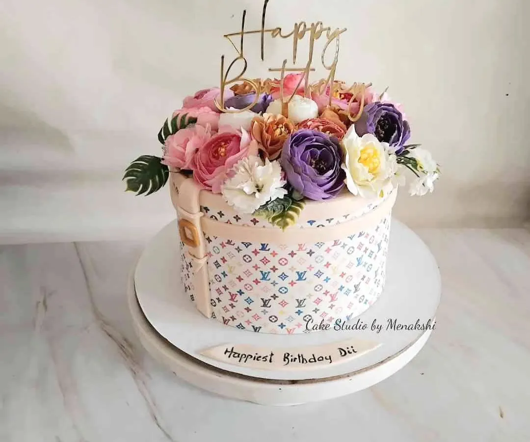 For a very special sister, I designed this elegant Louis Vuitton inspired hat box cake. It's topped with a beautiful bouquet of handmade sugar flowers, combining luxury fashion with delicate artistry.