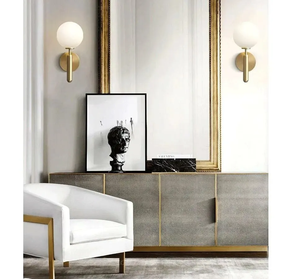 I love using wall lights to create symmetry and frame key features. Here, a pair of my modern globe sconces in a brushed brass finish flank a statement mirror, adding a layer of sophisticated, ambient light to the console area.