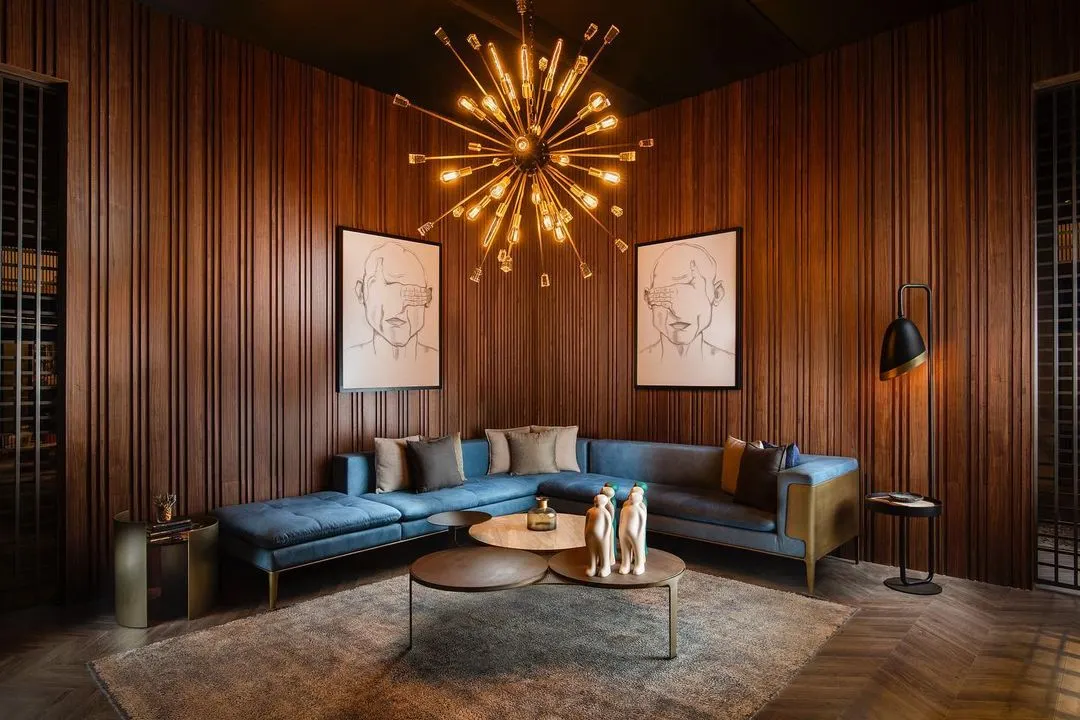 I designed this living room to feel both grand and intimate. The vertical wood wall panelling provides a warm, textured backdrop that envelops the space, creating a sophisticated sanctuary for relaxation and conversation.