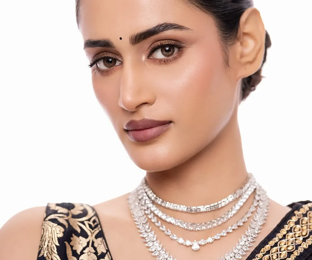 For a modern reception or cocktail event, I often suggest a sleek, layered diamond necklace. This piece, with its brilliant-cut stones and a striking emerald drop, offers a sophisticated sparkle that is both contemporary and timeless.