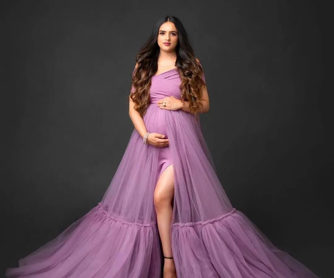 Feel radiant during your maternity shoot with our lavender gown. This studio portrait shows the dress's elegant drape and thigh-high slit, designed to beautifully highlight your baby bump.