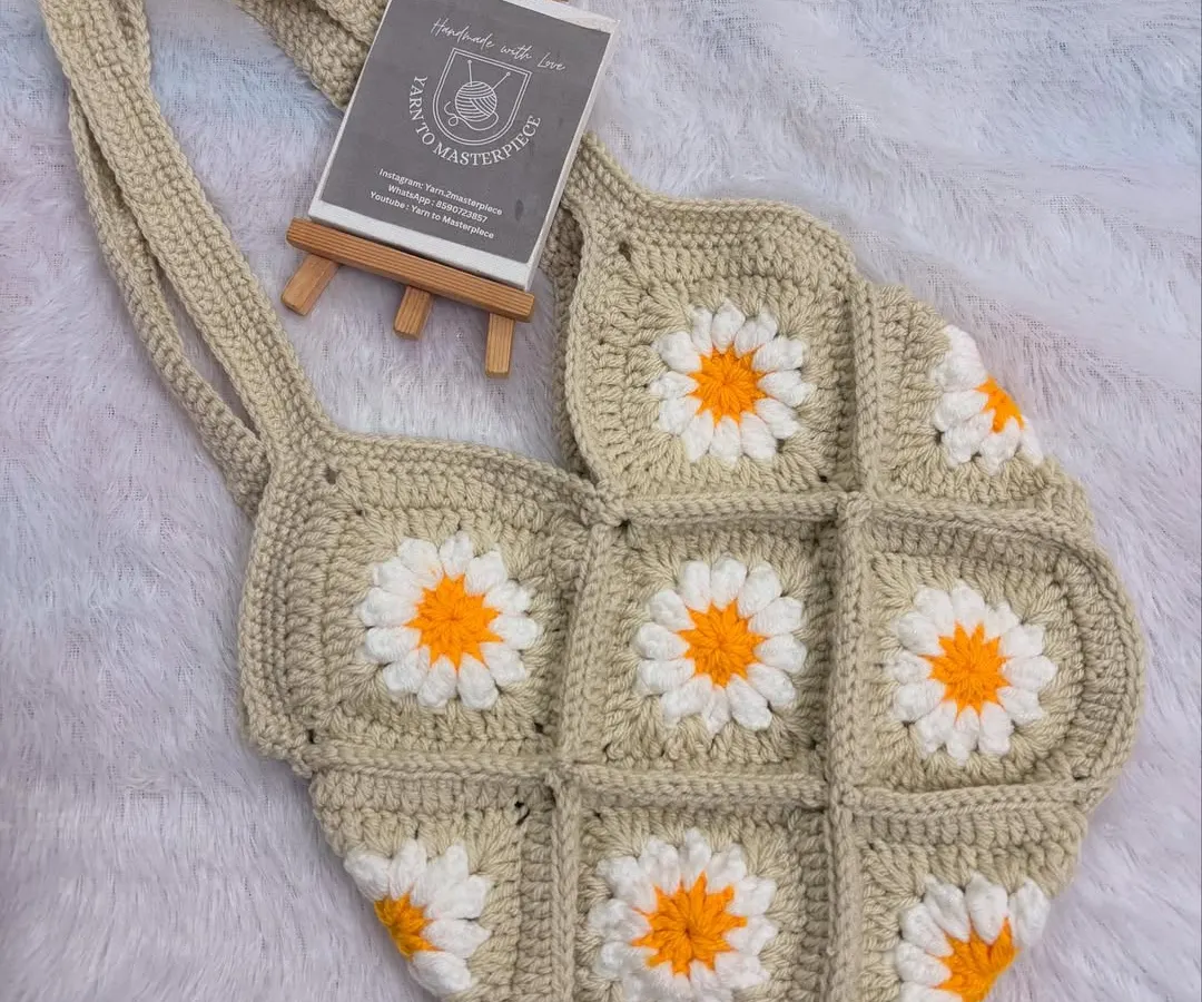 I love making these granny square daisy bags. This one, in a lovely neutral beige, is perfect for a breezy, boho-chic look. It's lightweight, made from 100% cotton yarn, and adds a touch of handmade charm to any outfit.