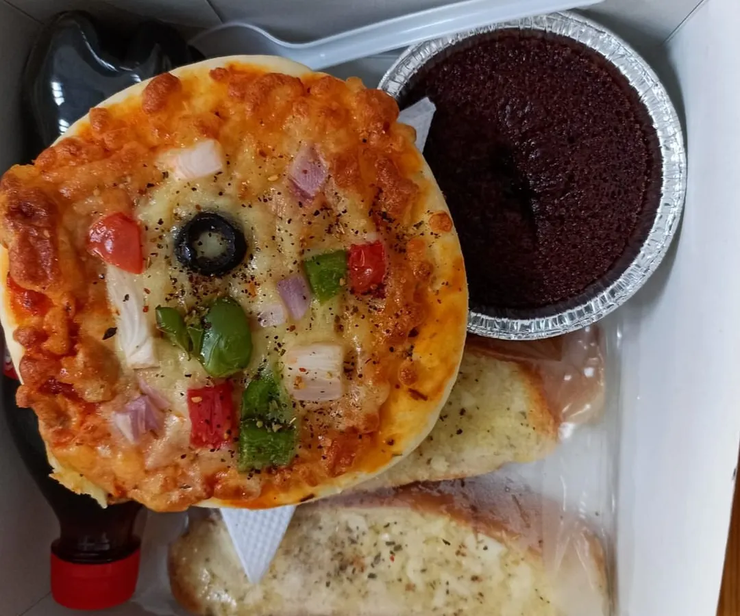 Mini pizza, garlic bread and chocolate cake sit together in one of our individual party snack boxes.