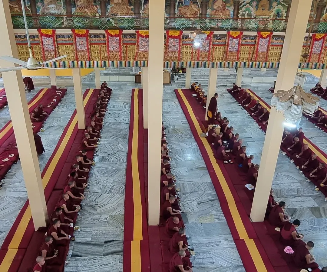 A view of the vast prayer hall during a ceremony at Sera Jey Monastery, filled with the Sangha community engaged in collective practice. This image captures the scale and serene dedication of monastic life.