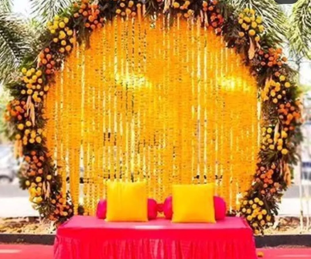 This is one of our most requested designs: a grand circular backdrop made entirely of fresh marigold flower strings. It creates a classic and auspicious setting for a Haldi ceremony, complete with comfortable seating for the main couple.
