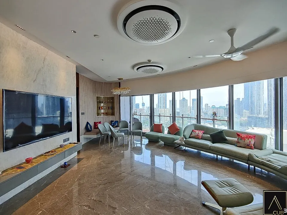 For the Jesrani Residence, the client requested a minimalist aesthetic. We designed this expansive living room to feel calm and uncluttered, using a gentle color scheme and a curved sofa that follows the building's form, all while maximizing the stunning panoramic city views.