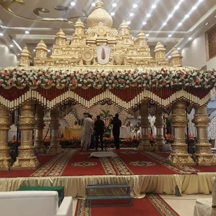 This is a great example of a grand, temple-style wedding mandap I designed. The intricate golden structure, combined with traditional red and white floral garlands, creates a divine and opulent atmosphere for the main ceremony.