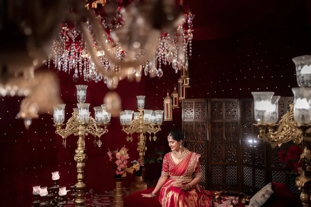 I love crafting portraits that feel both grand and personal. Here, the bride sits like royalty, surrounded by the warm glow of chandeliers, a timeless image of elegance and anticipation before her new beginning.