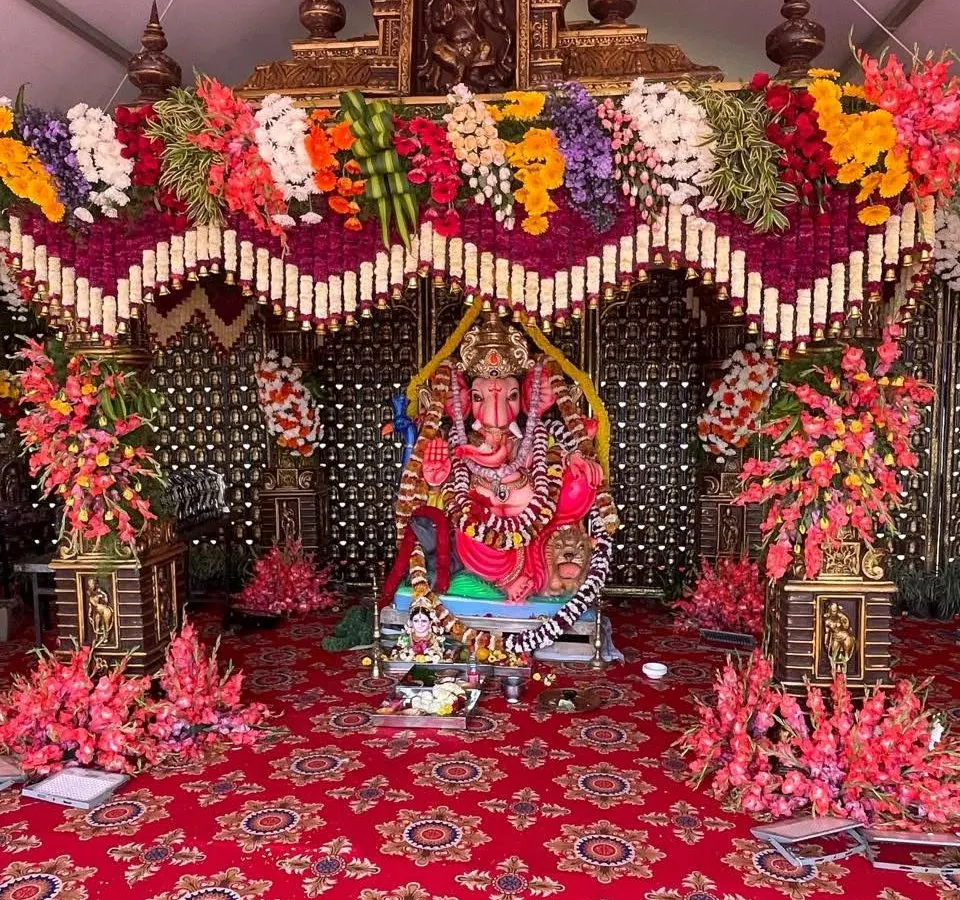 For large scale religious events and festivals, we provide grand decorations. Here is a complete pandal setup for a Ganesha pooja, with a multi-layered flower arch and traditional arrangements.