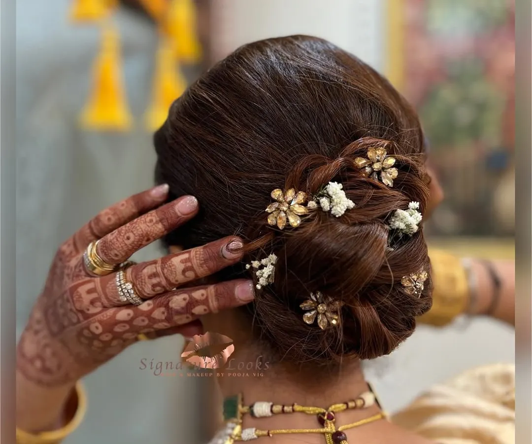 For the mother of the bride, I crafted this sophisticated twisted bun. It's a timeless and graceful updo, which I accented with small floral hairpins and gypsophila for a touch of royal elegance.