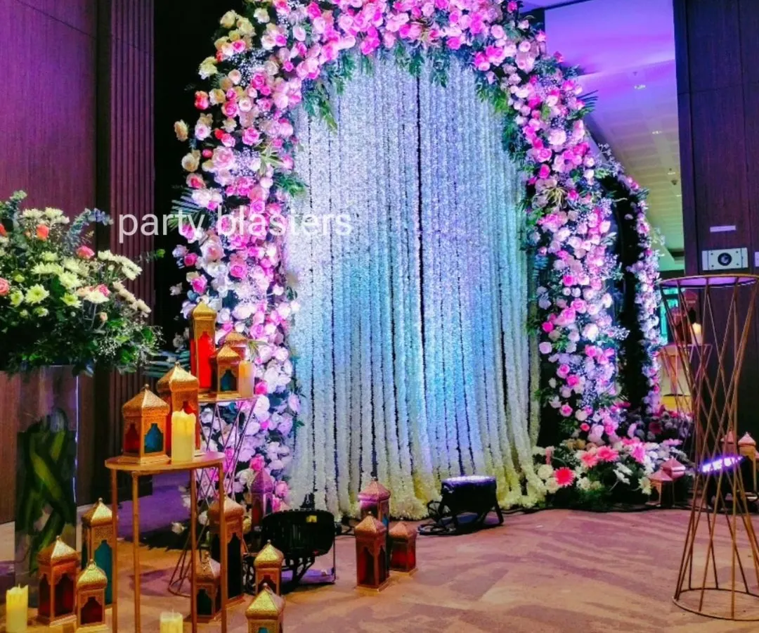 A breathtaking floral arch makes for an unforgettable entrance or photo backdrop. This design uses a cascade of fresh flowers in pink and white, with a curtain of jasmine strings that adds a touch of fragrant elegance.