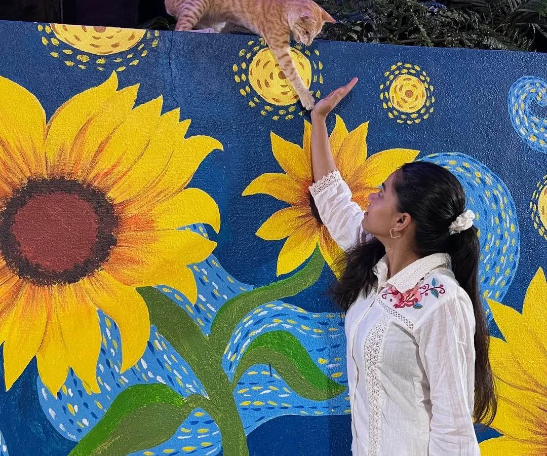 Here I am with a finished custom piece, a reinterpretation of Van Gogh's 'Starry Night' with bright sunflowers. Even a friendly cat couldn't resist taking a closer look.