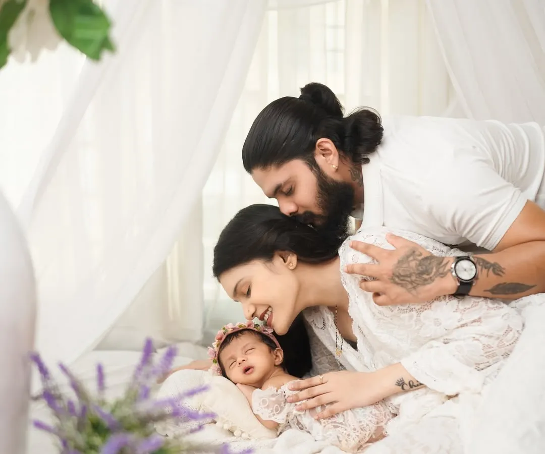 A serene and intimate portrait of new parents embracing their sleeping newborn. This light and airy style, set against a clean white backdrop, highlights the pure, peaceful connection of a new family.
