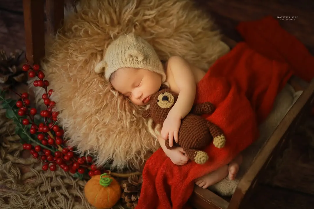A perfectly cozy and sleepy newborn, nestled with a tiny teddy bear. We use soft textures, warm tones, and simple props to create a safe and adorable setting, highlighting the baby's peacefulness during these first few weeks.