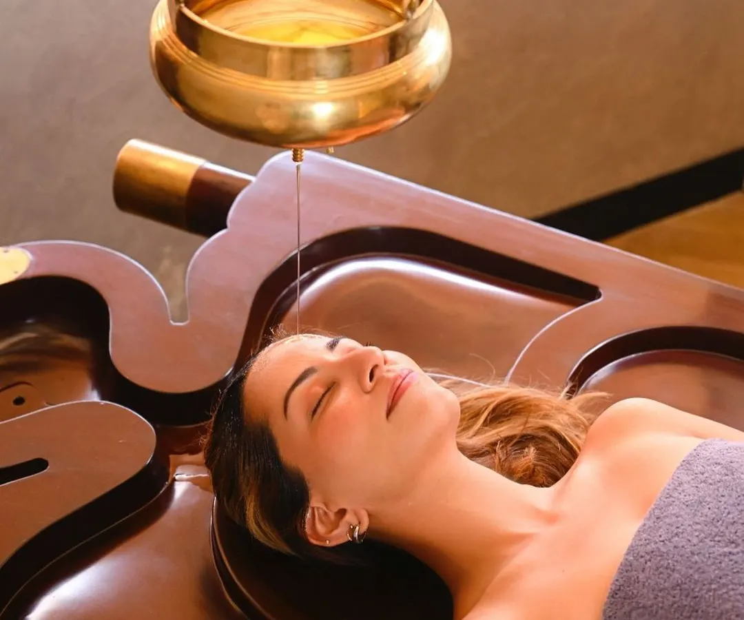 Experience the profound calm of Shirodhara, a timeless Ayurvedic therapy. A gentle, continuous stream of warm, herb-infused oil flows over your forehead, quieting the mind, soothing the nervous system, and restoring a sense of deep inner balance.
