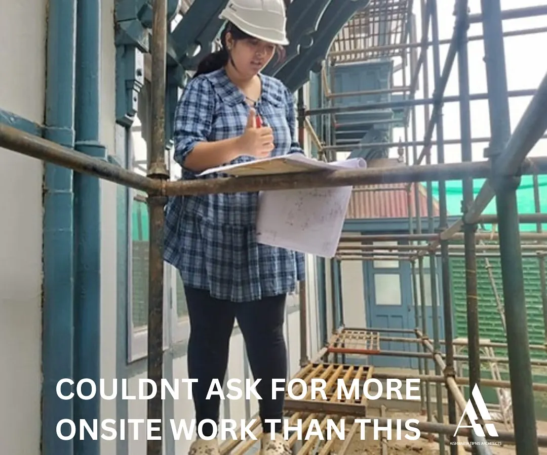 This is what our hands-on internship is all about. An intern stands on scaffolding at a live restoration site, reviewing architectural plans. We believe in learning by doing, and our interns gain invaluable experience in practical site management and conservation techniques.