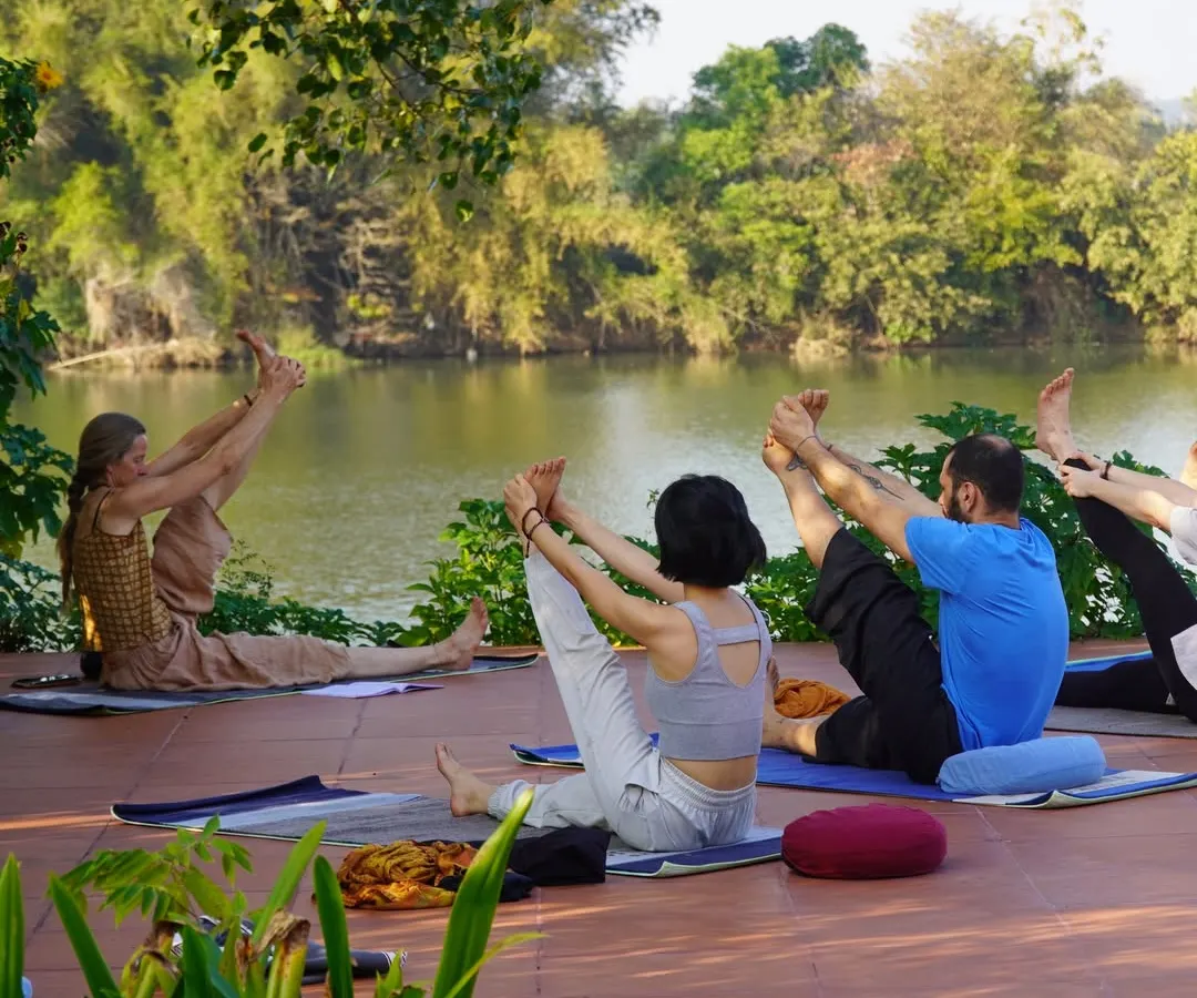 We take our practice into nature whenever we can. Here, our teacher training students find their focus and flexibility during an asana session on our riverside patio, connecting their breath with the gentle sounds of the water.