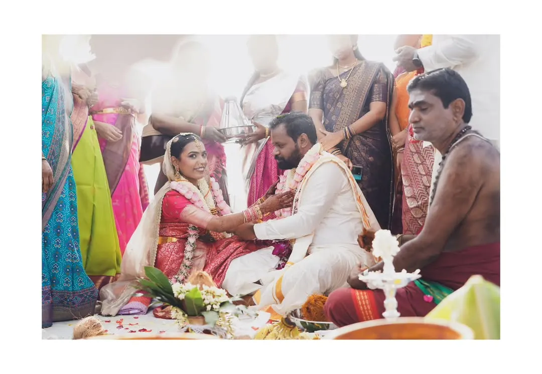 Capturing the quiet solemnity of a South Indian wedding ceremony. I focus on the meaningful details, like the exchange between the couple, surrounded by the vibrant colors of their family and traditions.