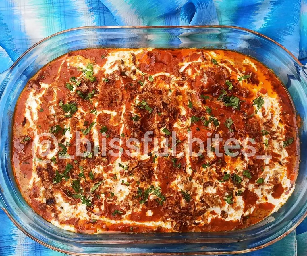 This is my signature Memon Malai Chicken. Unlike stove-top curries, I bake this dish to perfection. It has a rich red gravy base and is generously topped with malai (cream), fried onions, and fresh coriander, creating a wonderfully creamy and flavorful experience.