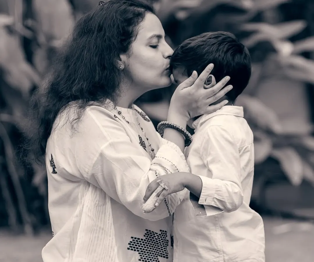 There is a unique tenderness in black and white photography. This candid shot of a mother's kiss captures a fleeting, heartfelt moment that transcends color.