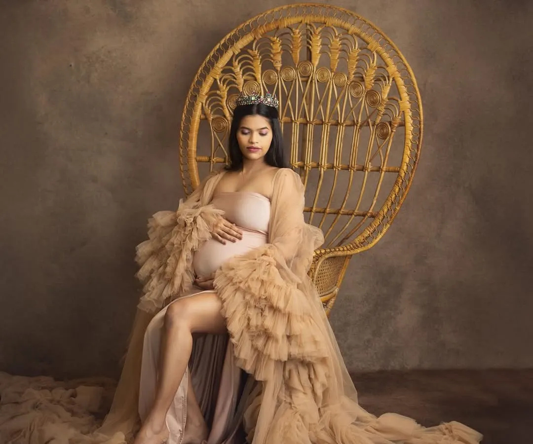 Every mother is a queen, and in my studio, we make that a reality. This portrait, with the regal peacock chair and a flowing tulle gown, is all about celebrating your strength and grace in a timeless, elegant style.