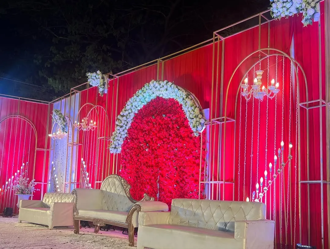 For clients who love bold statements, I designed this stunning all-red wedding stage. The combination of a dense red floral backdrop, elegant white seating, and modern gold frames creates a look of pure opulence.