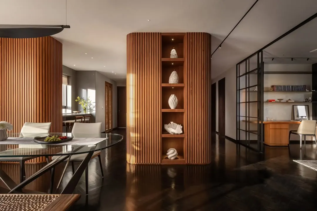 In the 'Rambagh' residence, we used curved, fluted wood panelling to create a warm, enveloping core that separates living areas while maintaining an open feel. This structure doubles as a display for curated art, reflecting our focus on integrating bespoke architectural elements that are both functional and beautiful.