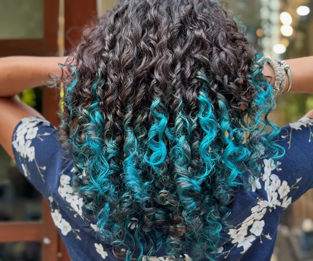 Who says you can't have fun with color? This vibrant turquoise dip-dye adds a playful pop of personality while keeping the roots natural and the curls healthy and defined.