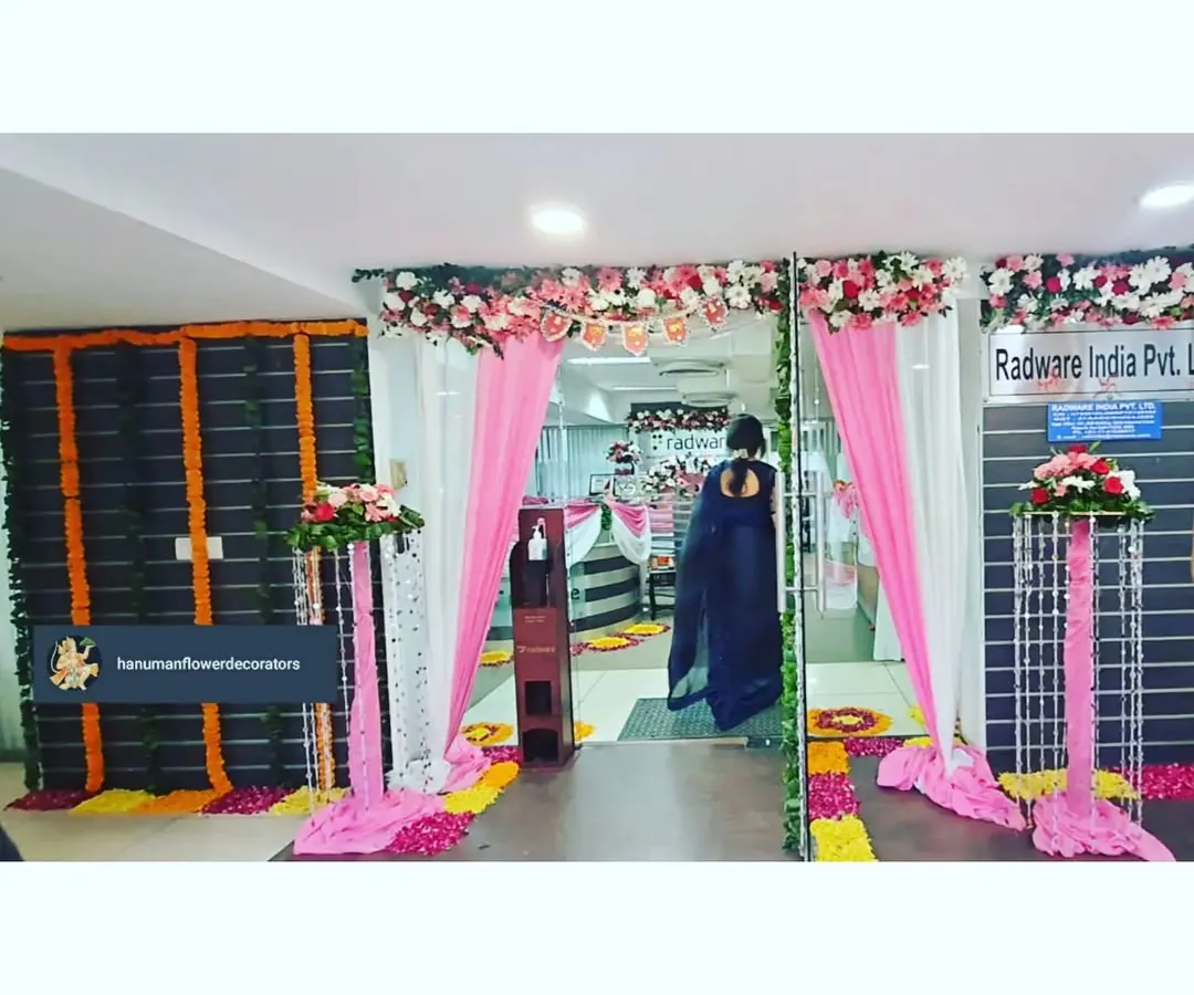 Here’s how we transform a corporate office entrance for a festival. For Radware India, we used bright pink and white fabric drapes, floral pillars, and a traditional flower path to create a welcoming and celebratory atmosphere for employees and visitors.
